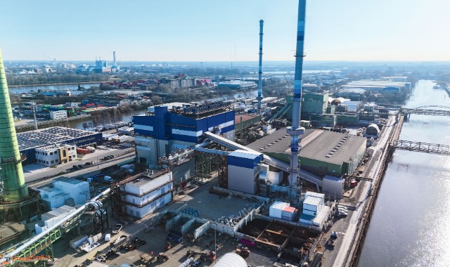 Aerial view of the Aurubis industrial site in Hamburg, with smelter buildings, tall stacks and the river alongside the plant.